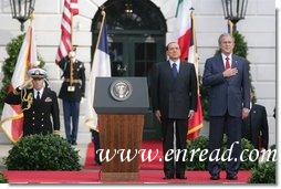 President George W. Bush and Prime Minister Silvio Berlusconi stand together on the reviewing stand Monday, Oct. 13, 2008 on the South Lawn of the White House, during the playing of the National Anthem. White House photo by Chris Greenberg