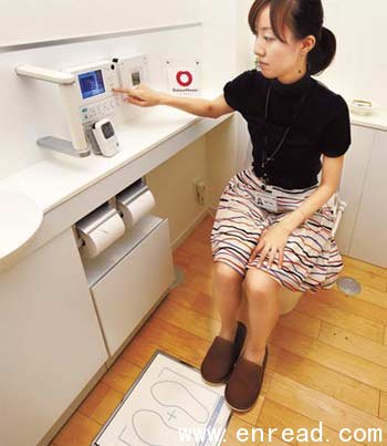 An employee of Japan's housing company Daiwa House demonstrates the company's latest model, called 'Intelligence Toilet', manufactured by Toto, at Daiwa House show room in Tokyo.