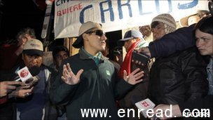 Reporters were waiting for miner Carlos Mamani (C) at his home after his release from hospital