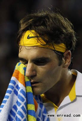 Roger Federer of Switzerland wipes his face during his semi-final match against Novak Djokovic of Serbia at the Australian Open tennis tournament in Melbourne Jan 27, 2011.