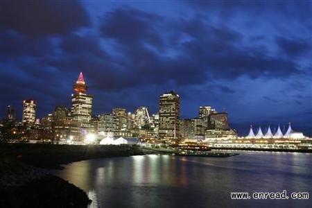 Clouds gather above the night skyline of downtown Vancouver during the Vancouver 2010 Winter Olympics February 25, 2010.