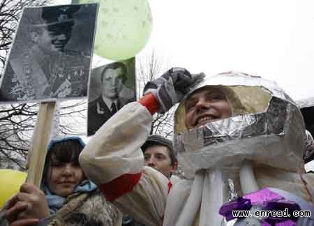 Members of a creative group hold placards with portraits of Yuri Gagarin and wear cosmonaut costumes during a performance in Moscow April 12, 2011.
