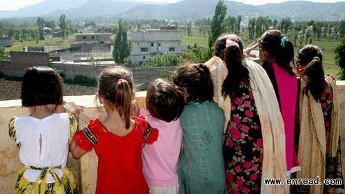 Pakistani children make the most of a vantage point to see Bin Laden\s final bolthole in Abbottabad. Sightseers have been flocking to the site this week