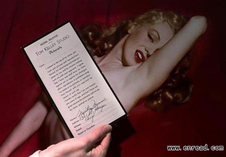 An employee of Butterfields auction house displays a copy of a model release signed by Marilyn Monroe in front of one of the photographs of Monroe during a Hollywood photo shoot in 1949, in Los Angeles, March 22, 2001.