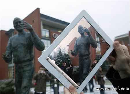 A man takes pictures with his iPad during the unveiling ceremony of a statue of the late Apple co-founder Steve Jobs at a private business park in Budapest December 21, 2011.