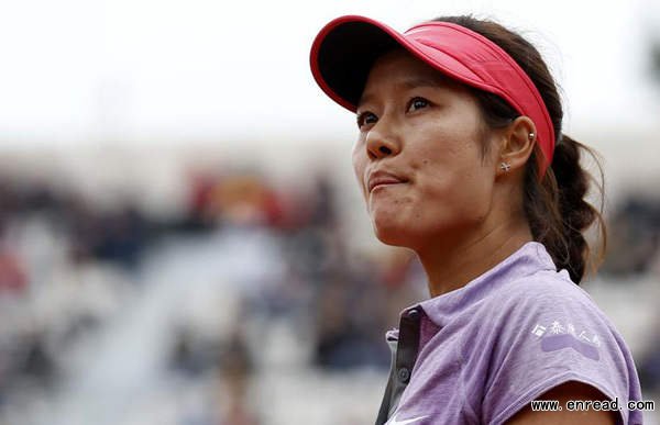 Li Na of China reacts after losing her women's singles match against Kristina Mladenovic of France in the first round of French Open tennis tournament at the Roland Garros stadium in Paris, May 27, 2014.