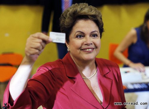 Brazil's President and Workers' Party (PT) presidential candidate Dilma Rousseff holds up her voter's card before voting in the runoff election in Porto Alegre October 26, 2014.
