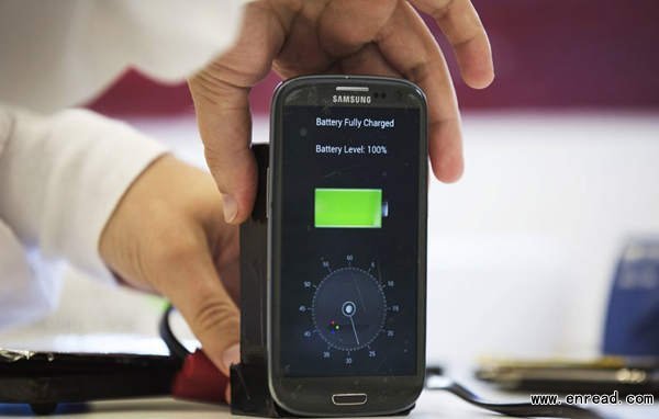 A lab worker disconnects from a charger a mobile phone, displaying a timer indicating that the battery was <a href=
