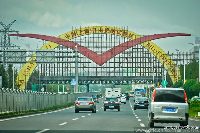 Cars travel past the construction site of Shanghai Free Trade Zone in Shanghai, China, 23 September 2013.