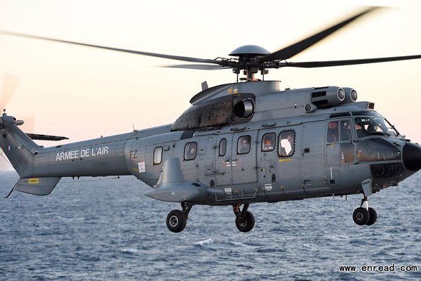 French President Francois Hollande (C) looks out from a window of a helicopter as he departs the French nuclear aircraft carrier Charles de Gaulle after he presented his New Year wishes to the French military forces January 14, 2015 off the coast of Toulon, southern France.