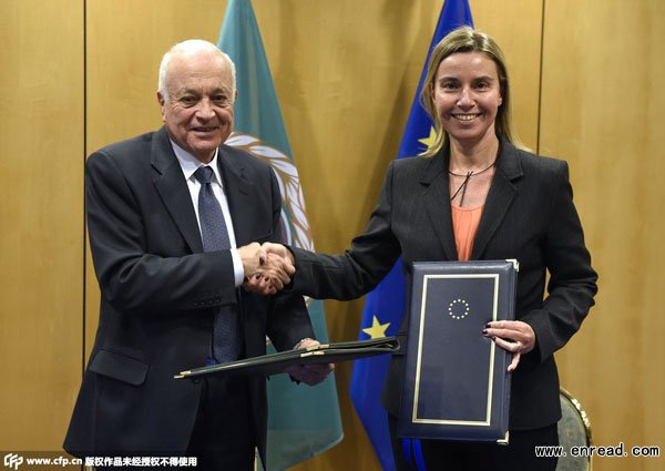EU foreign policy chief Federica Mogherini (R) shakes hands with Arab League chief Nabil al-Arabi as they sign a <a href=