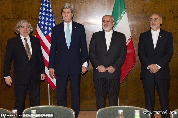US Secretary of State John Kerry (2nd L) stands next to Iranian Foreign Minister Mohammad Javad Zarif (2nd R) as they prepare to take their seats for a new round of nuclear negotiations in Montreux, Switzerland, on March 2, 2015.