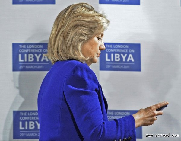 Former U.S. Secretary of State Hillary Clinton checks her mobile phone before a conference at the Foreign & <a href=